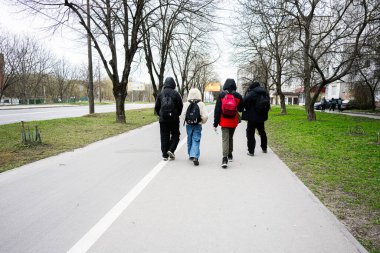 Khmelnytskyi, Ukrayna - 16 Nisan 2025: Bulutlu bir günde okul arkadaşları kaldırımda yürüyorlar