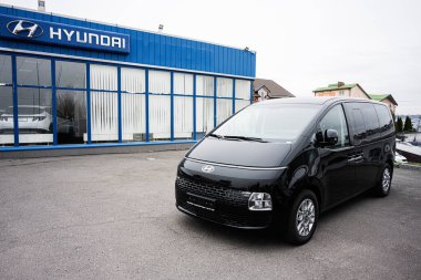 Khmelnytskyi, Ukrayna - 16 Nisan 2025: Modern bir bayilik binasının önünde siyah bir Hyundai Staria minibüsü duruyor