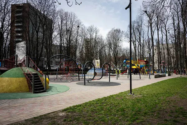 Khmelnytskyi, Ukrayna - 16 Nisan 2025: Şehir ortamında tırmanma ekipmanları, slayt ve yeşillik içeren renkli oyun alanı.