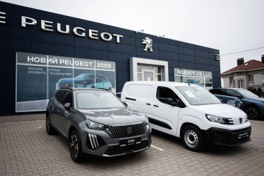 Khmelnytskyi, Ukrayna - 16 Nisan 2025: Peugeot araba dükkanı ve modern mimari sergilenen birçok araç