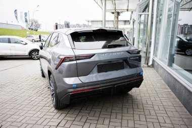 Khmelnytskyi, Ukrayna - 16 Nisan 2025: Gri Jetour SUV fayanslı döşeme üzerindeki bir otomobil bayii binasının önünde sergilendi.