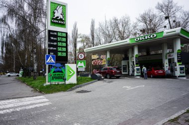 Khmelnytskyi, Ukrayna - 16 Nisan 2025: Hareketli bir OKO benzin istasyonu, sakin bir doğal ortamda yakıt ikmali yapan araçları barındırıyor.