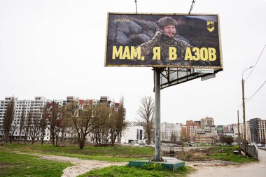 Khmelnytskyi, Ukrayna - 16 Nisan 2025: AZOV askeri temalı mesajı bina ve karayolu yakınlarındaki bir şehir ortamında gösteren pano.