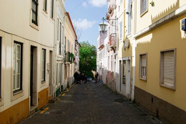 Caldas da Rainha, Portekiz - 17 Nisan 2025: Renkli evler ve yeşilliklerle çevrili Caldas da Rainha Portekiz 'de Picturesque dar kaldırım taşı caddesi