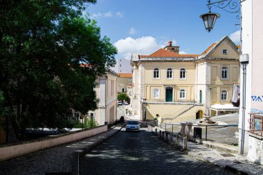 Portekiz 'in Caldas da Rainha şehrinde tarihi binaları olan güneşli bir kaldırım taşı caddesi..