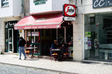 Caldas da Rainha, Portekiz - 17 Nisan 2025: Caldas da Rainha gelateria Segafredo Zanetti ve müşterilerle güneşli bir günün tadını çıkaran büfe.