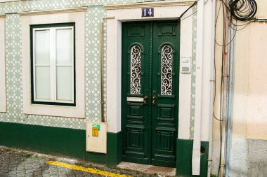 Süslü yeşil kapı ve Portekiz 'de Caldas da Rainha' da desenli cephe, mimari cazibe sergileniyor.