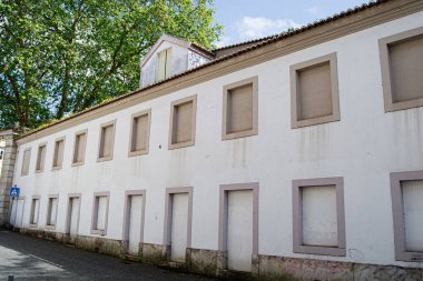 Portekiz, Caldas da Rainha 'da pencereleri ve ağaçları kapalı terk edilmiş bina cephesi