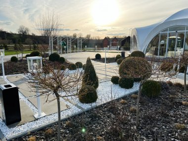 Okhrymivtsi, Ukrayna - 23 Nisan 2025: Altın saat boyunca modern mimariye sahip bir bahçe düzeninin yer aldığı zarif bir manzara.