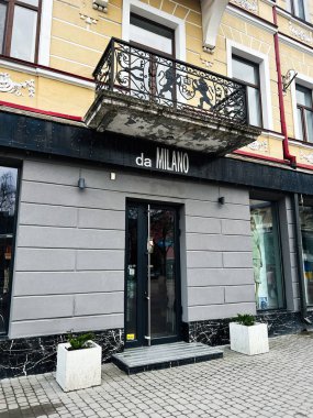 Ternpil, Ukrayna - 23 Nisan 2025: Modern mağaza önü da Milano girişi klasik mimari tasarım ile dekoratif bir balkon altında