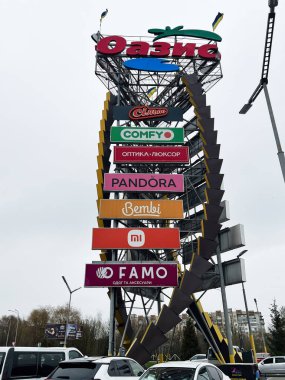 Khmelnytsky, Ukrayna - 23 Nisan 2025: Nüfusun yoğun olduğu bir yerdeki yüksek bir reklam Oasis yapısında birden fazla marka logosu sergilendi