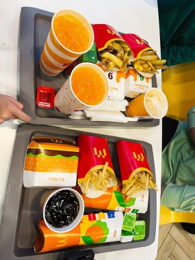 Ternpil, Ukrayna - 23 Nisan 2025: Lezzetli McDonald 's hamburgerleri, patates kızartmaları ve içecekler tepsilerde sunuluyor..