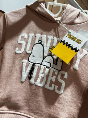 Kyiv, Ukrayna - 23 Nisan 2025: Peanuts karakteri Snoopy ve 'Sunday Vibes' tipografisi olan kapüşonlu kazak