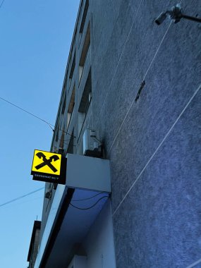 Ternpil, Ukrayna - 23 Nisan 2025: Akşamları aydınlık Raiffeisen Bank Aval ATM tabelasına sahip kentsel bir bina manzarası.