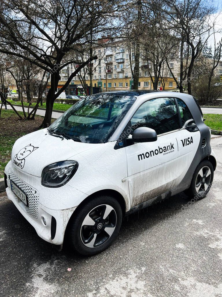 Kyiv, Ukraine - April 23, 2025: Small electric Smart ForTwo EQ car featuring advertising designs parked in a residential neighborhood
