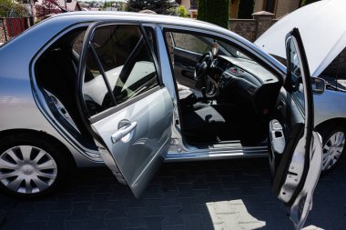 Kyiv, Ukrayna - 28 Nisan 2025: Gümüş Mitsubishi Lancer Sedan arabası açık kapılarla dolu açık bir garaj yoluna park edilmiş
