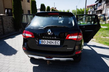 Kyiv, Ukrayna - 28 Nisan 2025: Siyah Renault Koleos asfalt bir yerleşim alanında açık kapılı.