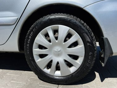 Kyiv, Ukrayna - 28 Nisan 2025: Lastik ve gümüş jant kapaklı Mitsubishi Lancer araç tekerleğinin ayrıntılı fotoğrafı