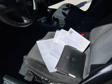 Kyiv, Ukrayna - 28 Nisan 2025: Mitsubishi Lancer 'ın park etmiş arabasının ön yolcu koltuğundaki belgeler ve klasör
