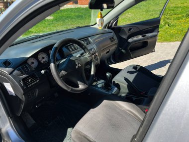 Kyiv, Ukrayna - 28 Nisan 2025: Mitsubishi Lancer iç mekanı, parlak güneş ışığı altında direksiyon, ön panel ve manuel vites kutusu