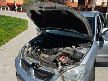 Kyiv, Ukrayna - 28 Nisan 2025: Kaputu kaldırılmış gümüş Mitsubishi Lancer motor bölümünü ayrıntılı olarak gösteriyor
