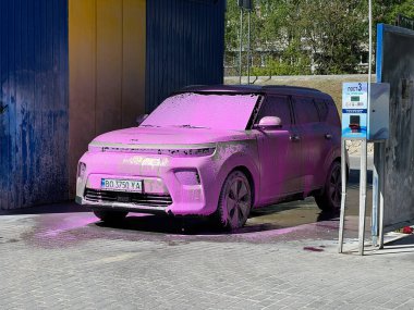 Kyiv, Ukrayna - 28 Nisan 2025: Kia Soul otomatik oto yıkama istasyonunda mor köpükle kaplandı.