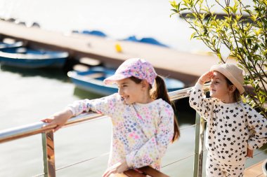 İki gülümseyen çocuk nehir kenarında eğleniyor..