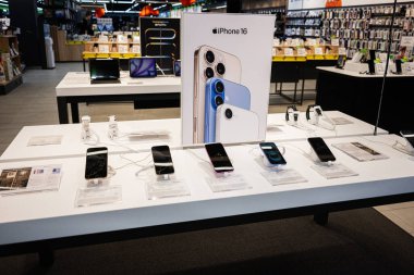 Ivano-Frankivsk, Ukrayna - 29 Nisan 2025: Akıllı telefonlar İphone 16 ve aksesuarlar, parlak örgütlü kurulumlu bir perakende elektronik mağazasında sergileniyor