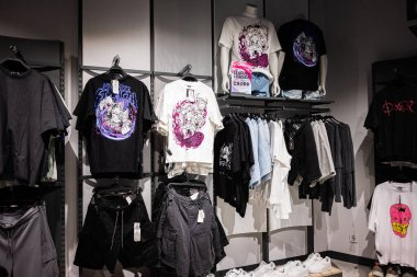 Ivano-Frankivsk, Ukrayna - 29 Nisan 2025: Bir mağazada grafik tişörtler, kot şortlar ve şık moda sergileniyor.