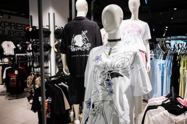 Ivano-Frankivsk, Ukrayna - 29 Nisan 2025: Parlak, şık bir moda mağazasında canlı grafik tişörtler giyen mankenler