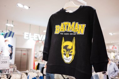 Ivano-Frankivsk, Ukrayna - 29 Nisan 2025: Perakende mağazasındaki askılarda Batman logosu bulunan şık siyah kazak