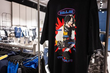 Ivano-Frankivsk, Ukrayna - 29 Nisan 2025: Billie Eilish grafik tasarımı içeren şık tişört, moda bir giyim mağazasında sergilendi. Sert ve Yumuşak Vur Turuna.