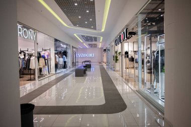 İvano-Frankivsk, Ukrayna - 29 Nisan 2025: Her iki tarafta da şık mağazalar ve geniş geçitler gösteren parlak ışıklı alışveriş merkezi koridoru