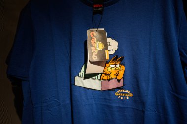 Ivano-Frankivsk, Ukrayna - 29 Nisan 2025: Garfield çizgi film karakteri grafiği ve 1978 yapımı klasik temalı mavi tişörtün kapanışı.