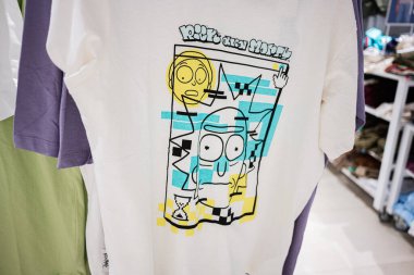 Ivano-Frankivsk, Ukrayna - 29 Nisan 2025: Bir giyim mağazasında sergilenen grafiksel tasarım tişörtü, Rick ve Morty 'nin renkli çizgi film tarzını gözler önüne seriyor.