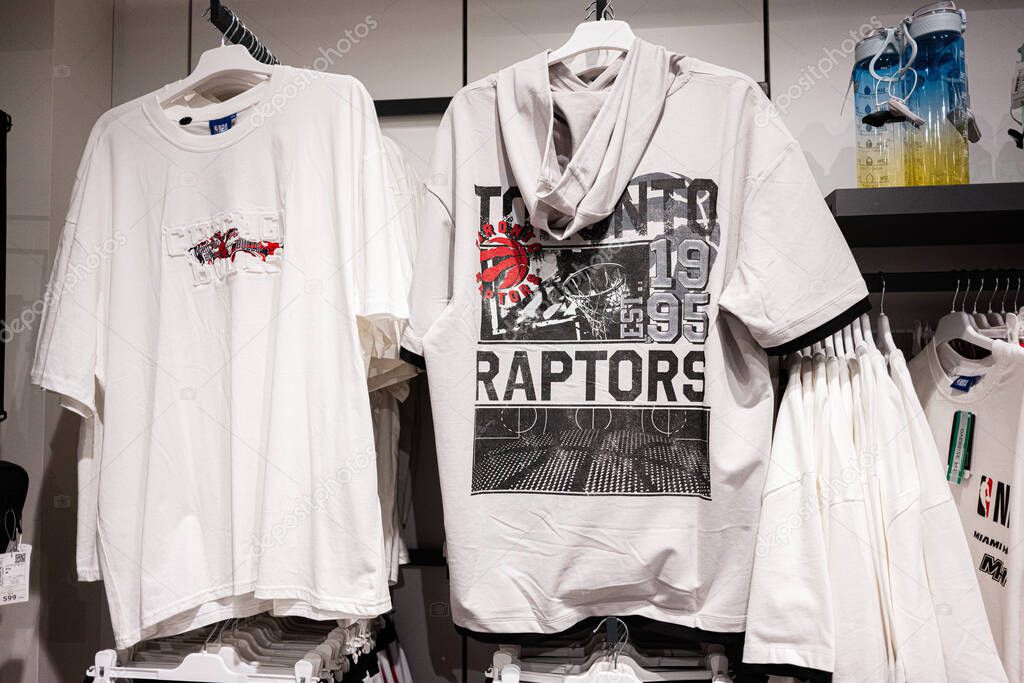 Ivano-Frankivsk, Ukraine - April 29, 2025: Stylish Toronto Raptors inspired t-shirts displayed on hangers in a clothing store
