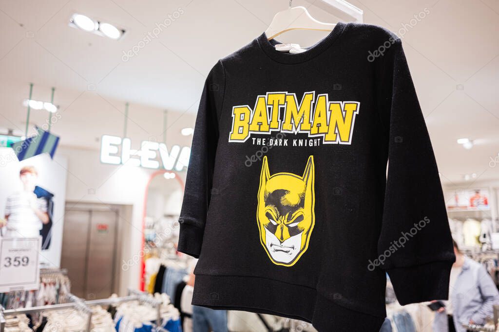 Ivano-Frankivsk, Ukraine - April 29, 2025: Stylish black sweatshirt featuring Batman logo on hangers in retail store setting