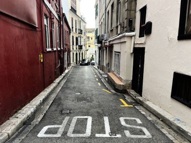 Gibraltar, İngiltere - 1 Mayıs 2025: Gibraltar şehir sokak manzarası klasik binalar ve görünür bir dur işareti.