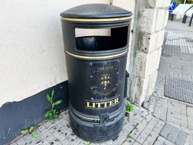 Cebelitarık, İngiltere - 01 Mayıs 2025: Taş kaldırım ve duvar kenarındaki bir sokak köşesinde bulunan açık hava Cebelitarık çöplüğü