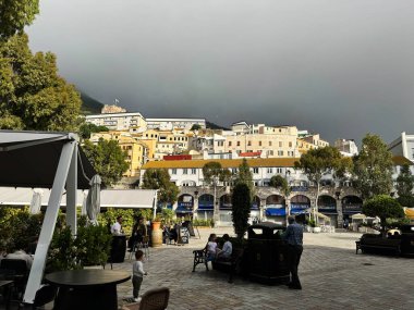 Cebelitarık, İngiltere - 01 Mayıs 2025: Yamaç binaları ve insanların Cebelitarık 'taki açık hava faaliyetlerini sevdiği canlı bir halk meydanı.