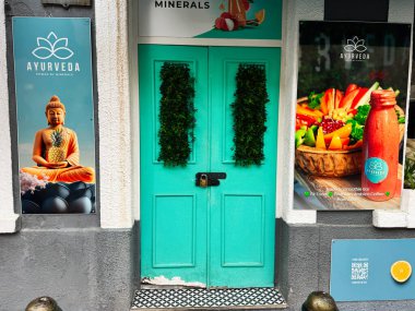 Gibraltar, İngiltere - 01 Mayıs 2025: Canlı temalar ve yeşil elementlerin yer aldığı ayurvedic posterlerle çevrili dekoratif giriş.