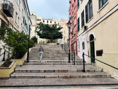 Cebelitarık, İngiltere - 01 Mayıs 2025: Cebelitarık 'ın canlı bölgesinde renkli binalar ve yeşilliklerle çevrili açık şehir merdivenleri