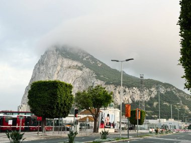Cebelitarık, İngiltere - 01 Mayıs 2025: Sakin bir kentsel alandaki atmosferik bulutların altındaki görkemli Cebelitarık Kayası.