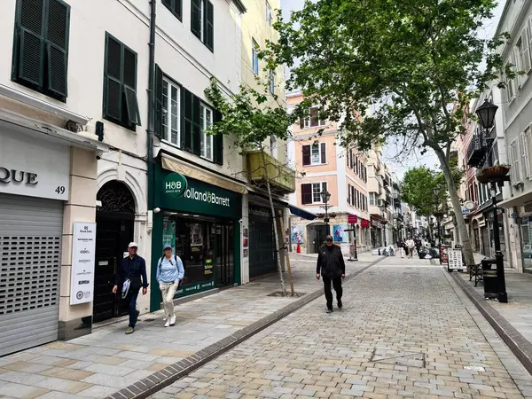 Cebelitarık, İngiltere - 01 Mayıs 2025: Dükkanlar, yemyeşil alanlar ve sakin kentsel ambiyansın yer aldığı yayalar.