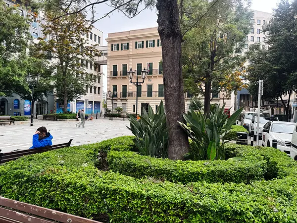 Cebelitarık, İngiltere - 1 Mayıs 2025: Birleşik Krallık 'ta yeşillik, banklar ve binaların yer aldığı sakin kentsel park sahnesi