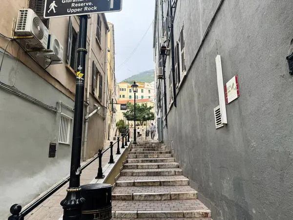 Cebelitarık, İngiltere - 01 Mayıs 2025: Cebelitarık, İngiltere topraklarında manzaralı manzaraya açılan merdivenli dar bir cadde