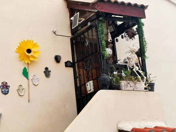 Cebelitarık, İngiltere - 01 Mayıs 2025: Ayçiçeği ve iskelet figürü de dahil olmak üzere dekoratif eşyalarla büyüleyici balkon görüntüsü.