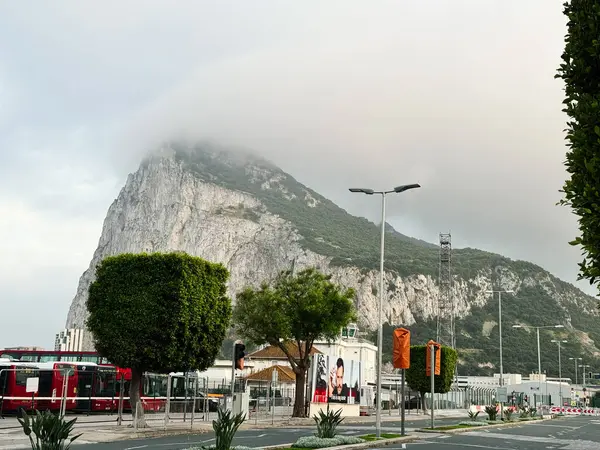 Cebelitarık, İngiltere - 01 Mayıs 2025: Sakin bir kentsel alandaki atmosferik bulutların altındaki görkemli Cebelitarık Kayası.