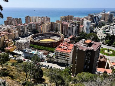 Malaga, İspanya - 02 Mayıs 2025: Plaza de toros de La Malagueta. Mavi gökyüzü altında boğa güreşi ve kıyı manzaralı Malaga şehrinin havadan görünüşü