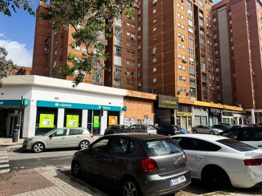 Malaga, İspanya - 02 Mayıs 2025: Malaga 'da yüksek katlı daireler, park edilmiş arabalar ve dükkanların yer aldığı kentsel yerleşim alanı